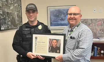 Patrol Officer Nick Conforti poses with Airport Director Chris Hastert
