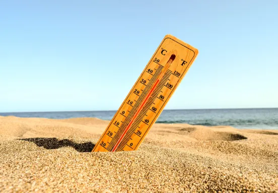  a closeup shot of a thermometer in the beach sand